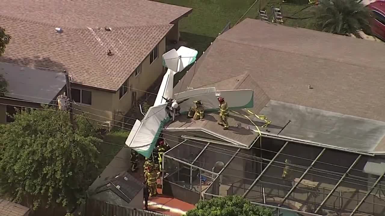 firefighters on roof helping to secure small plane that crashed into Miramar home, Oct. 17, 2022