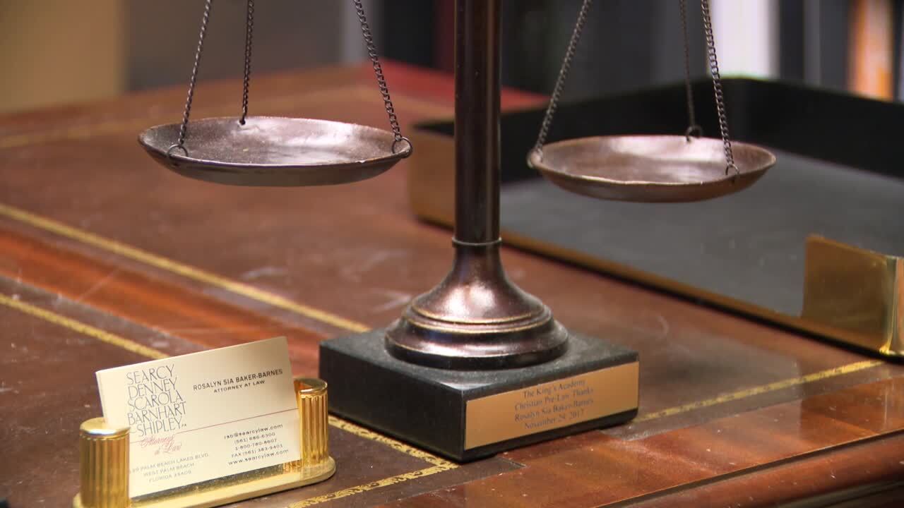 Sia Baker-Barnes business card next to scales of justice on her desk