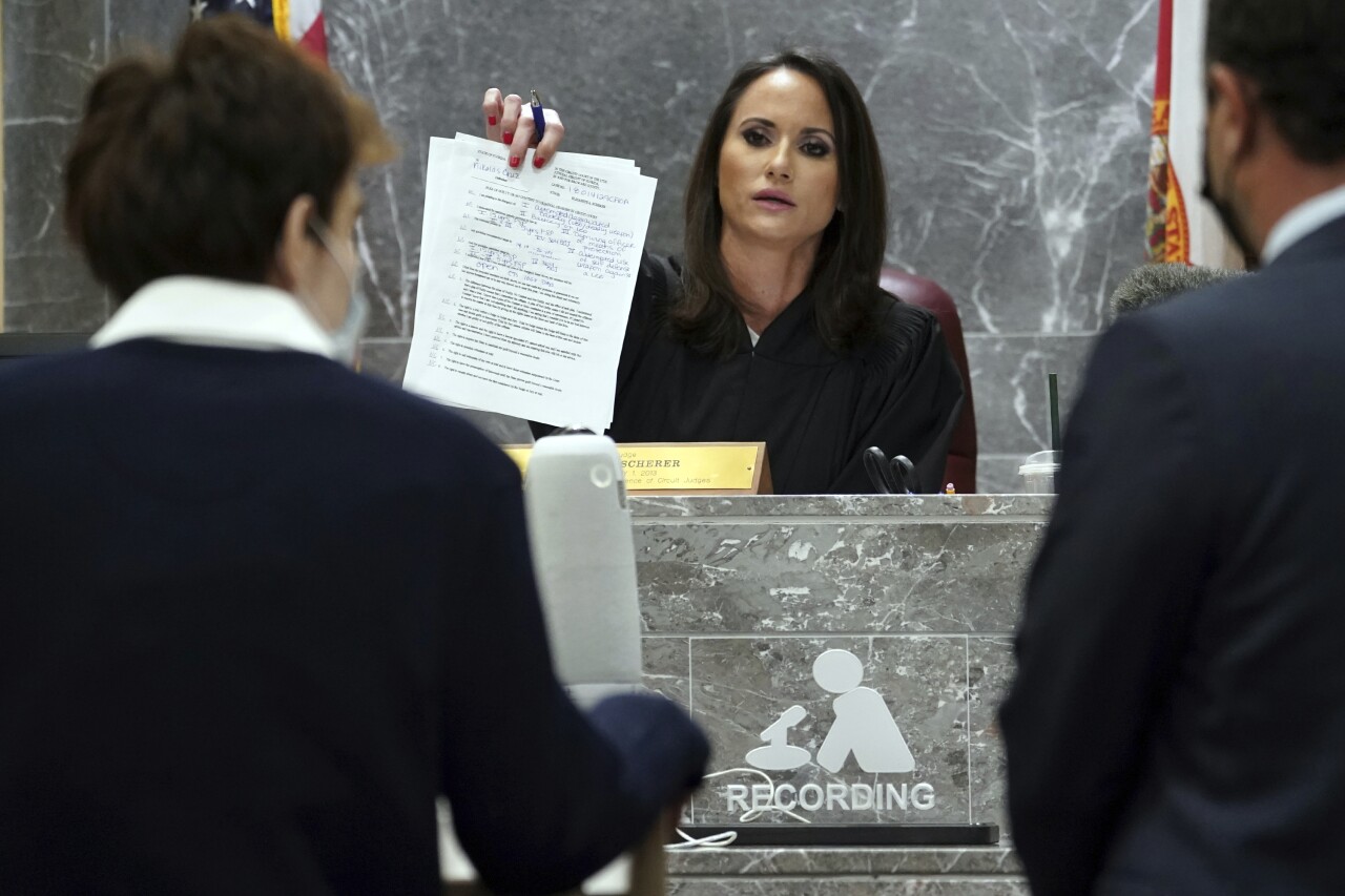 Broward County Judge Elizabeth Scherer holds up plea agreement in front of Nikolas Cruz, Oct. 15, 2021