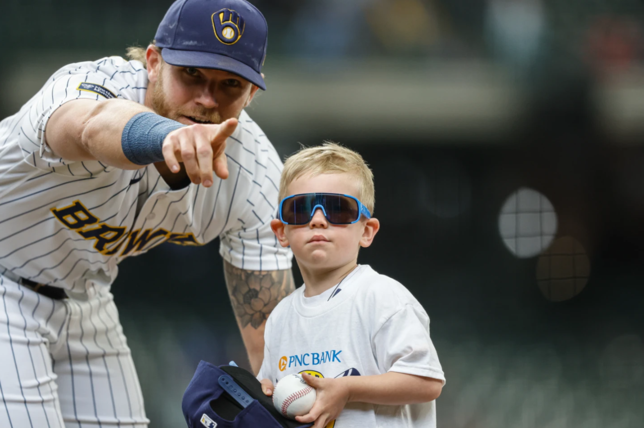 Milwaukee Brewers first baseman Jake Bauers (9) points a small boy back to the stands after signing an autograph before the first inning of a baseball game against the Pittsburgh Pirates Sunday, April 26, 2026, in Milwaukee.
