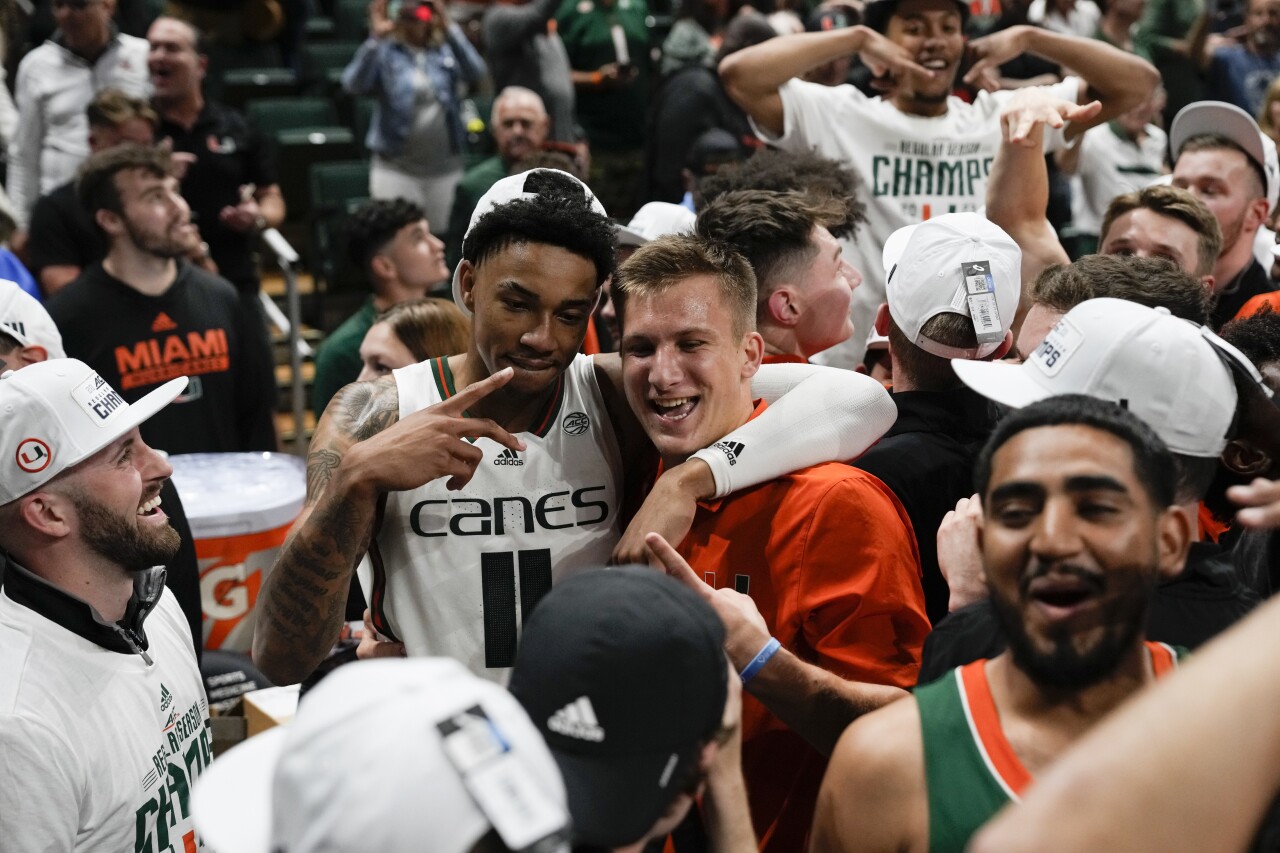 Miami Hurricanes guard Jordan Miller poses with fan after beating Pittsburgh Panthers to win ACC regular-season championship, March 4, 2023