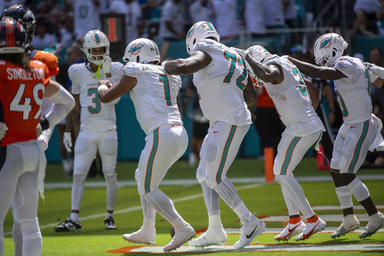 Miami Dolphins teammates QB Tua Tagovailoa, offensive tackle Terron Armstead, running back Raheem Mostert and receiver Tyreek Hill dance off field vs. Denver Broncos, Sept. 24, 2023