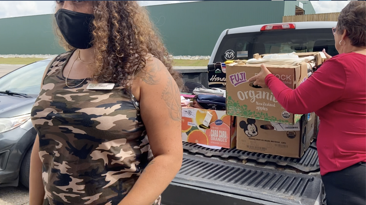 Community members load hundreds of backpacks onto a truck
