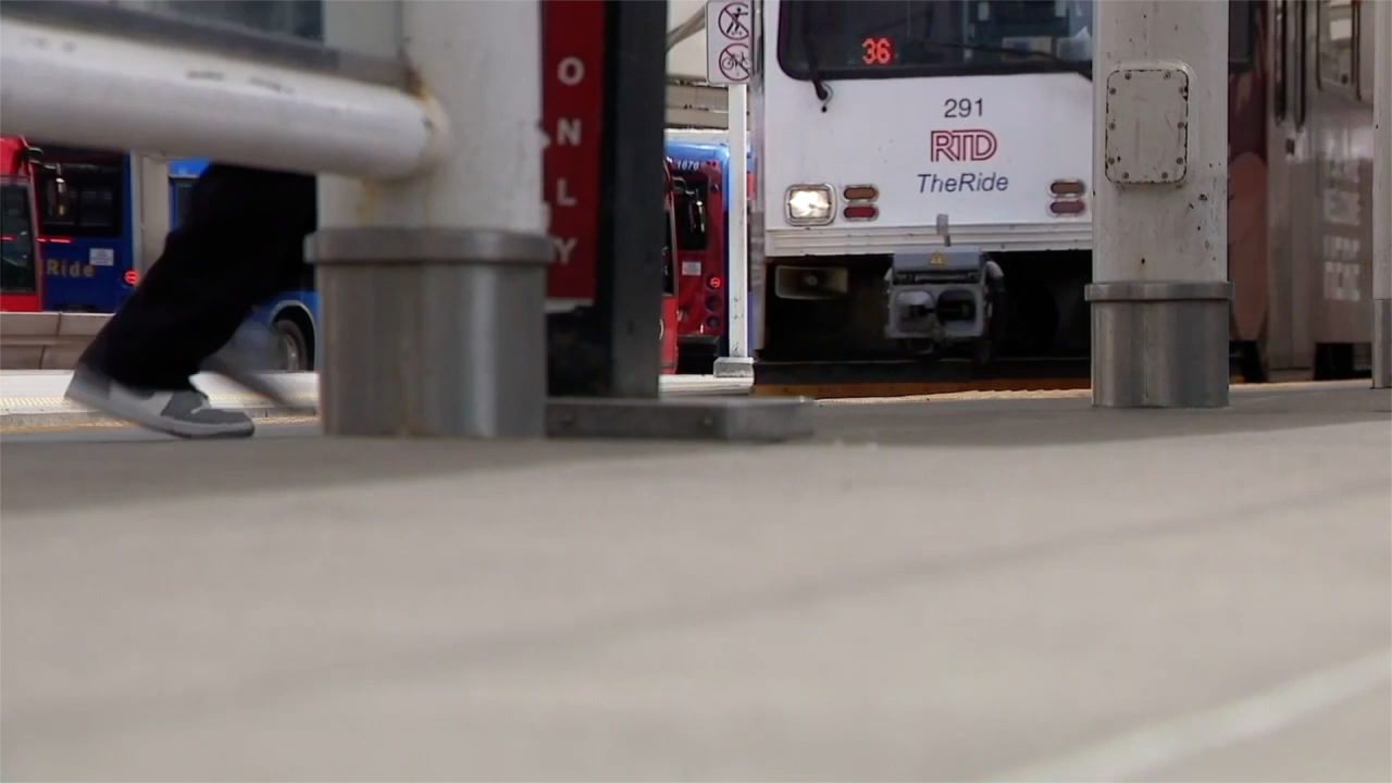 A passenger moves across an RTD light rail platform.