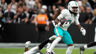 Miami Dolphins wide receiver Caleb Douglas (7) breaks a tackle by Las Vegas Raiders safety Jeremy Chinn (11) after catching a pass during the first half of an NFL football game, Sunday, Sept. 13, 2026, in Las Vegas.