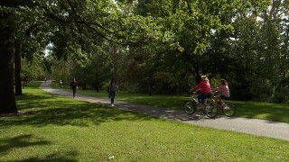 People walking and riding bikes on the Boise River Greenbelt near Zoo Boise.