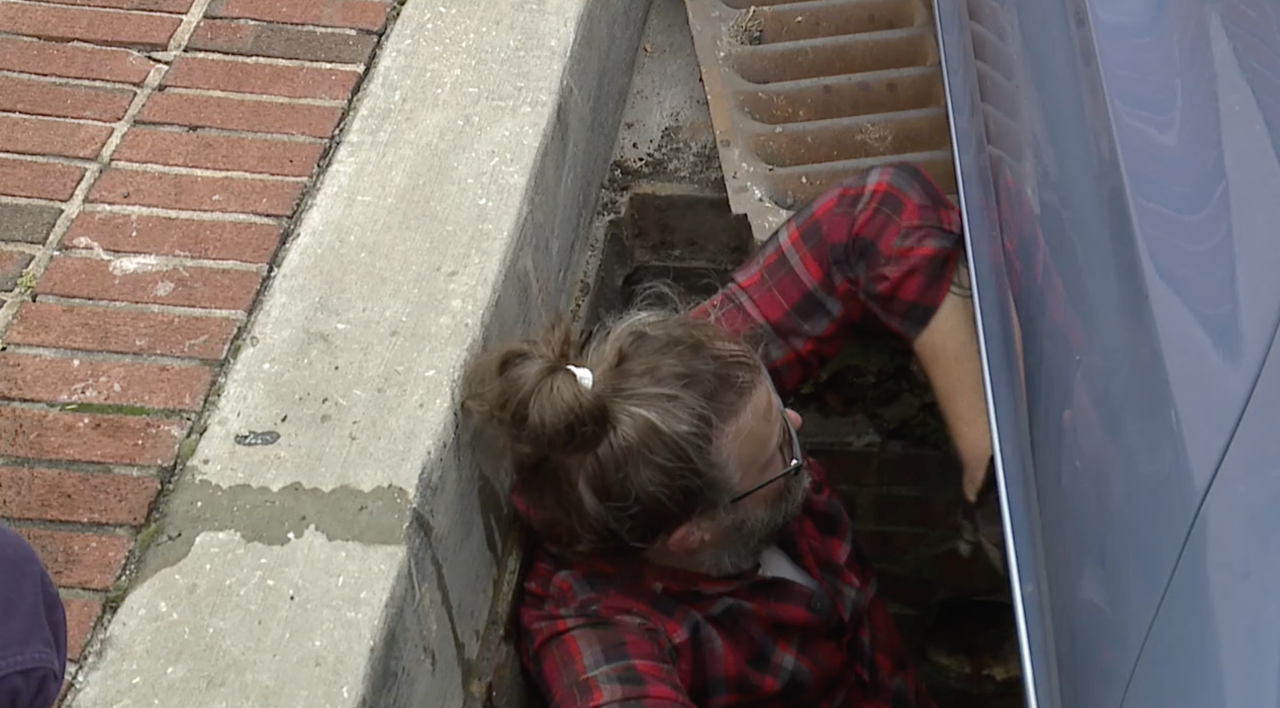Matthew Phillips lowering himself into the drain
