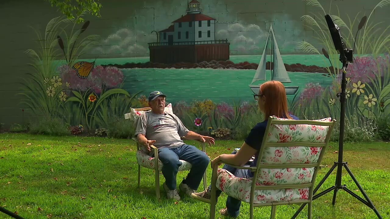 Joe Santiana, left, leads a nonprofit group that owns the historic Ashtabula Harbor Light. A local artist painted a mural of the lighthouse on an exterior wall at his antique shop in nearby North Kingsville.