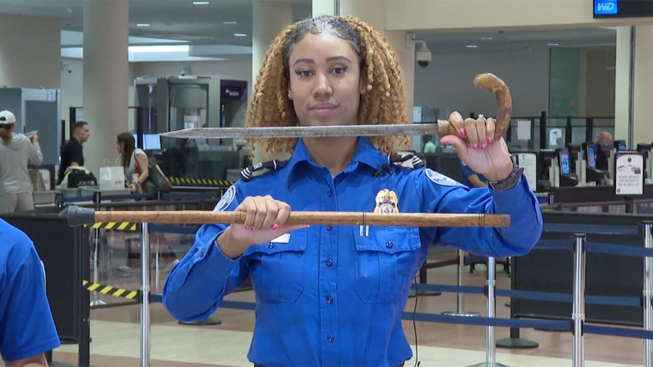 A TSA agent holds up a cane that is also a sword that was confiscated at Palm Beach International Airport in 2024. 