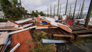 People retrieve belongings from a collapsed boat house in the aftermath of Hurricane Isaias in Destin, Fla., Saturday, Oct. 10, 2026. (AP Photo/Gerald Herbert)