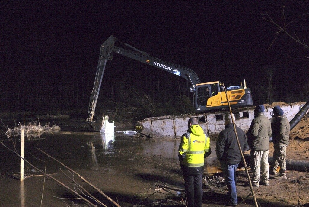 In this image provided by the U.S. Army, Lithuanian Army and emergency services personnel build a makeshift dam from HESCO barrier bags during recovery efforts for four U.S. soldiers in a U.S. Army M88 Hercules submerged under several meters of water in a swamp near a training area near Pabadre, Lithuania.