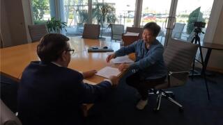Ying Pang shows court documents to Adam Walser