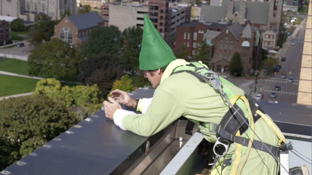Strapped into a safety harness, White hangs lights on the roof of the Louie.