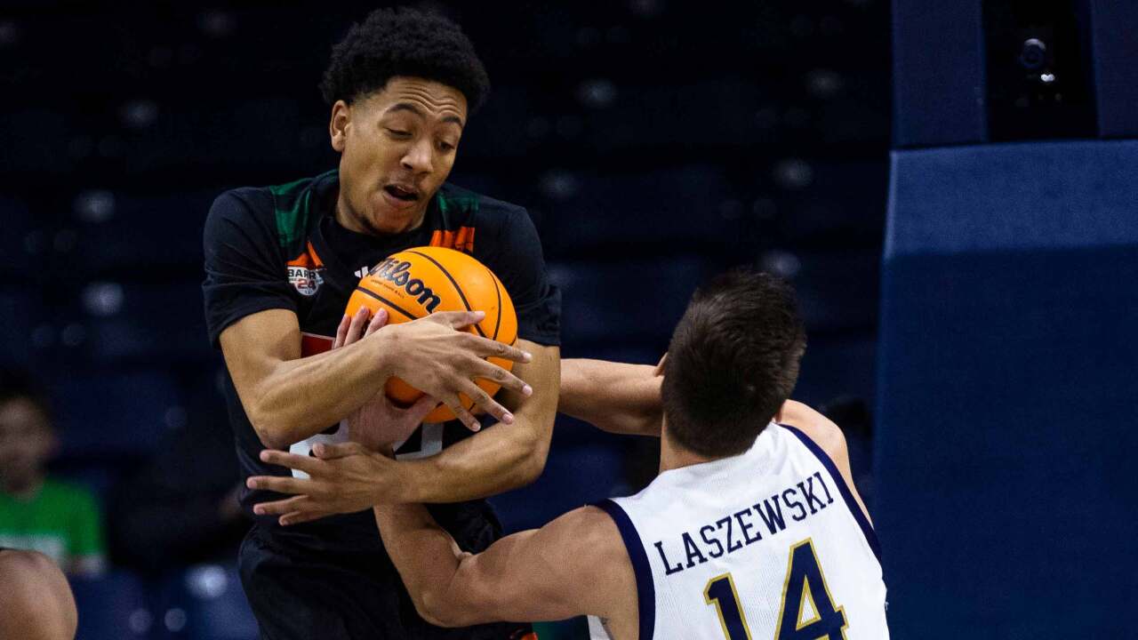 Miami's Nijel Pack, left, and Notre Dame's Nate Laszewski (14) fight for a loose ball during the first half of an NCAA college basketball game Friday, Dec. 30, 2022, in South Bend, Ind.