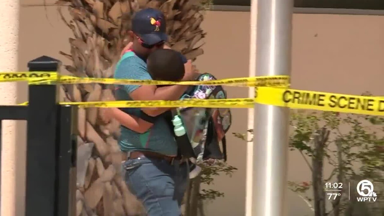 A father hugs his son following a lockdown at Berkshire Elementary School in Palm Beach County on Aug. 15, 2022.jpg