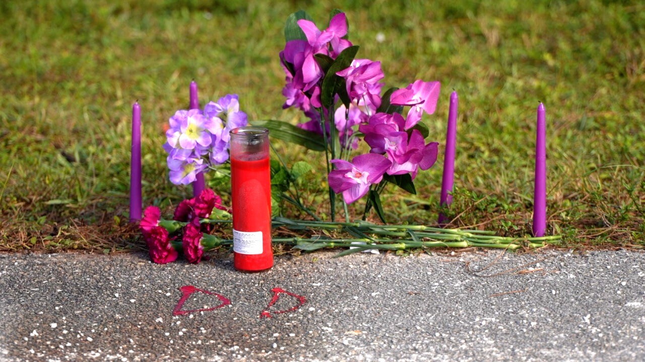 Memorial for Deshia Arthur, with her nickname "DD" spelled out on the road with candle wax.