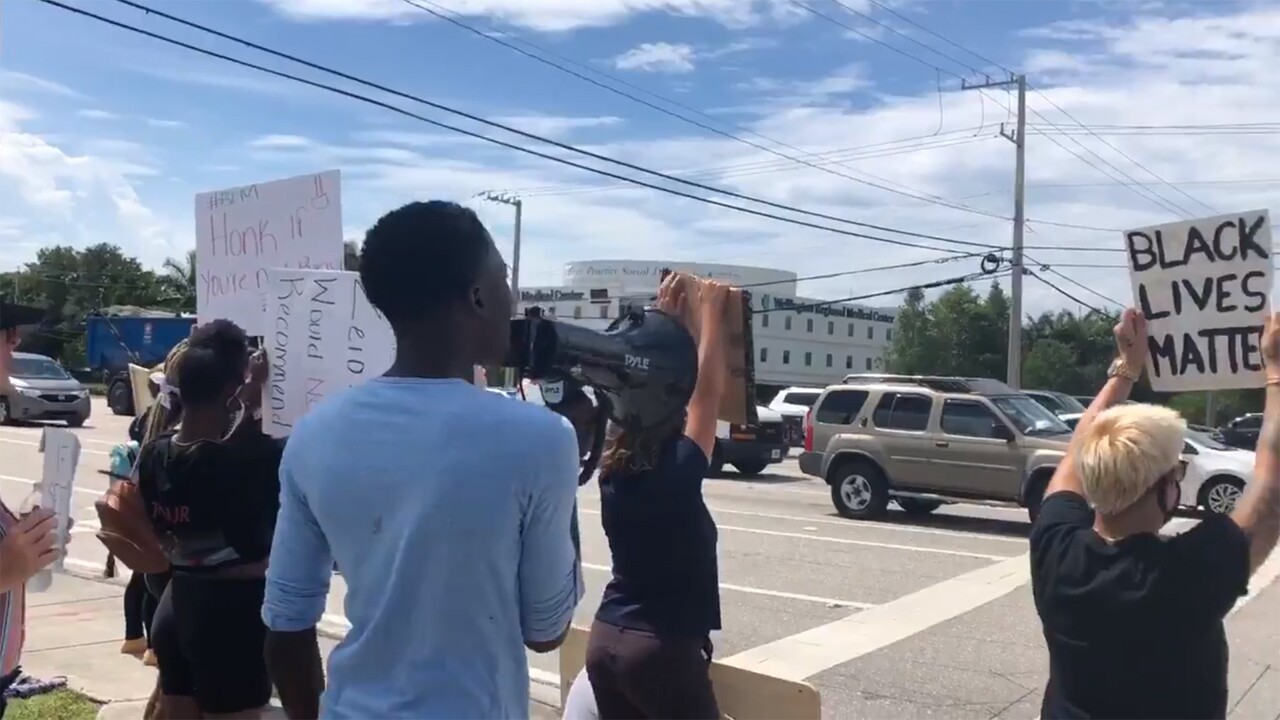 A group of protesters gathers at the intersection of Forest Hill Boulevard and Highway 441 in Wellington on Monday, June 8, 2020.