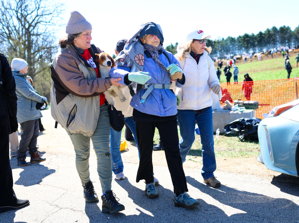 Activists help an elderly woman after she had been tear gassed during an attempt to gain entry into Ridglan Farms beagle breeding and research facility on Saturday, April 18, 2026, in Blue Mounds, Wis.