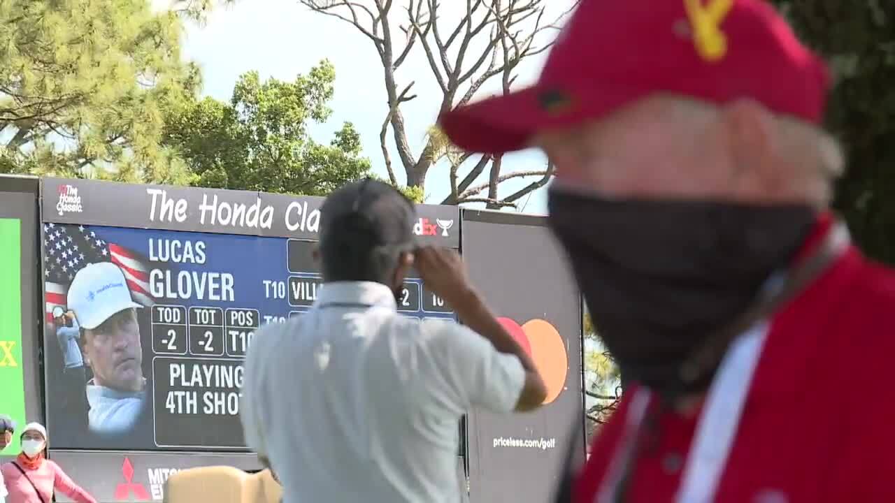 Electronic billboard for Lucas Glover on display at 2021 Honda Classic as Tom Gibbs waits in shade