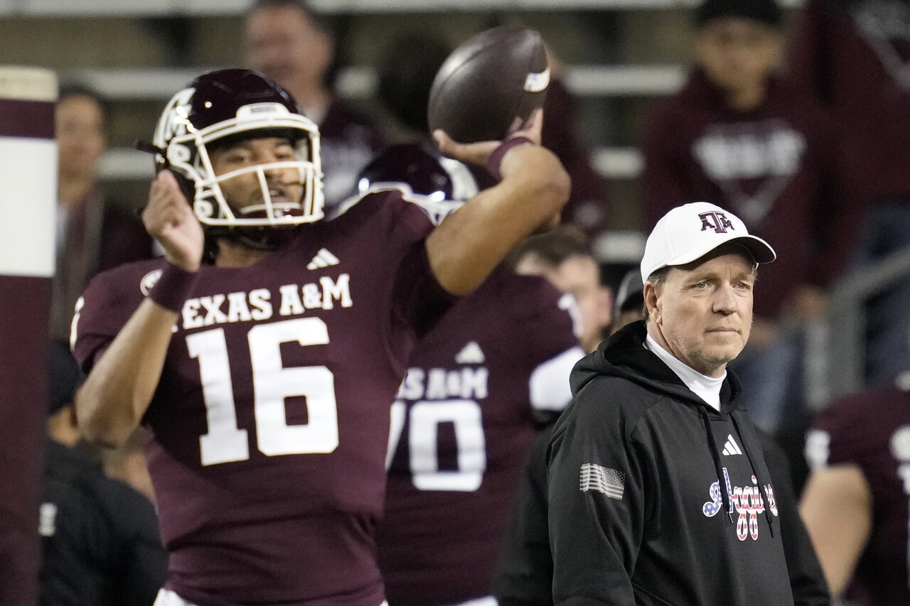 Texas A&M Aggies head coach Jimbo Fisher watches QB Jaylen Henderson warm up before game vs. Mississippi State Bulldogs, Nov. 11, 2023