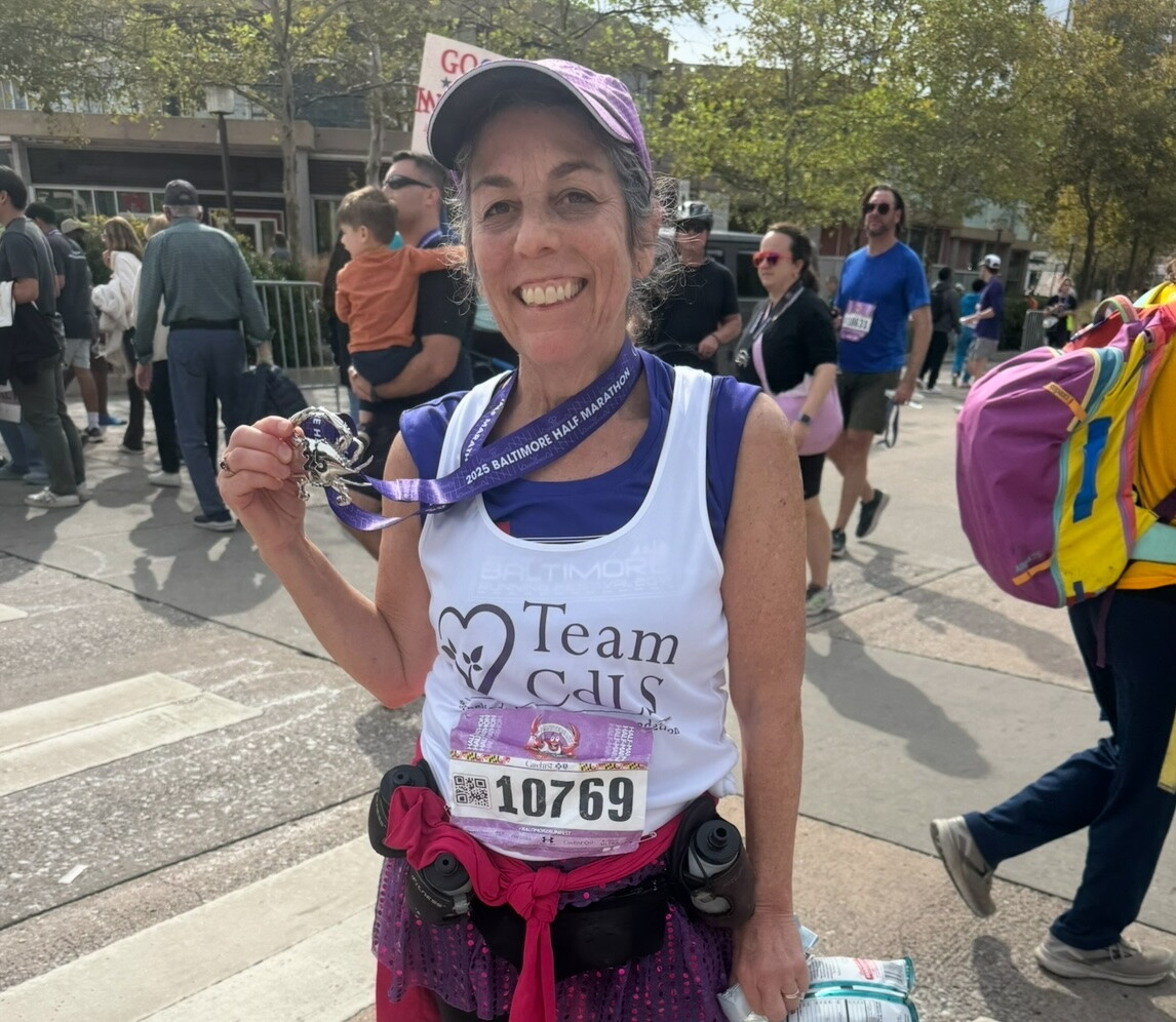 Dr. Kline holding her medal after running 13.1 miles