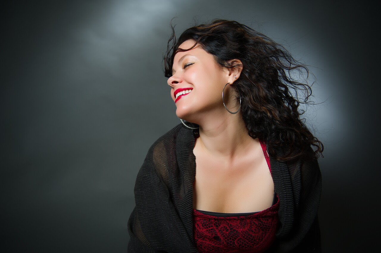 This portrait of Neshama Carlebach shows her long, wavy, dark hair blowing over her shoulder.