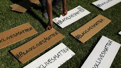 A protester picks up signs during a demonstration