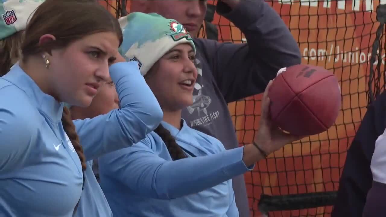 Camila Carmona, who plays on girls flag football team at Dr. Joaquin Garcia High School, poses with donated Dolphins football