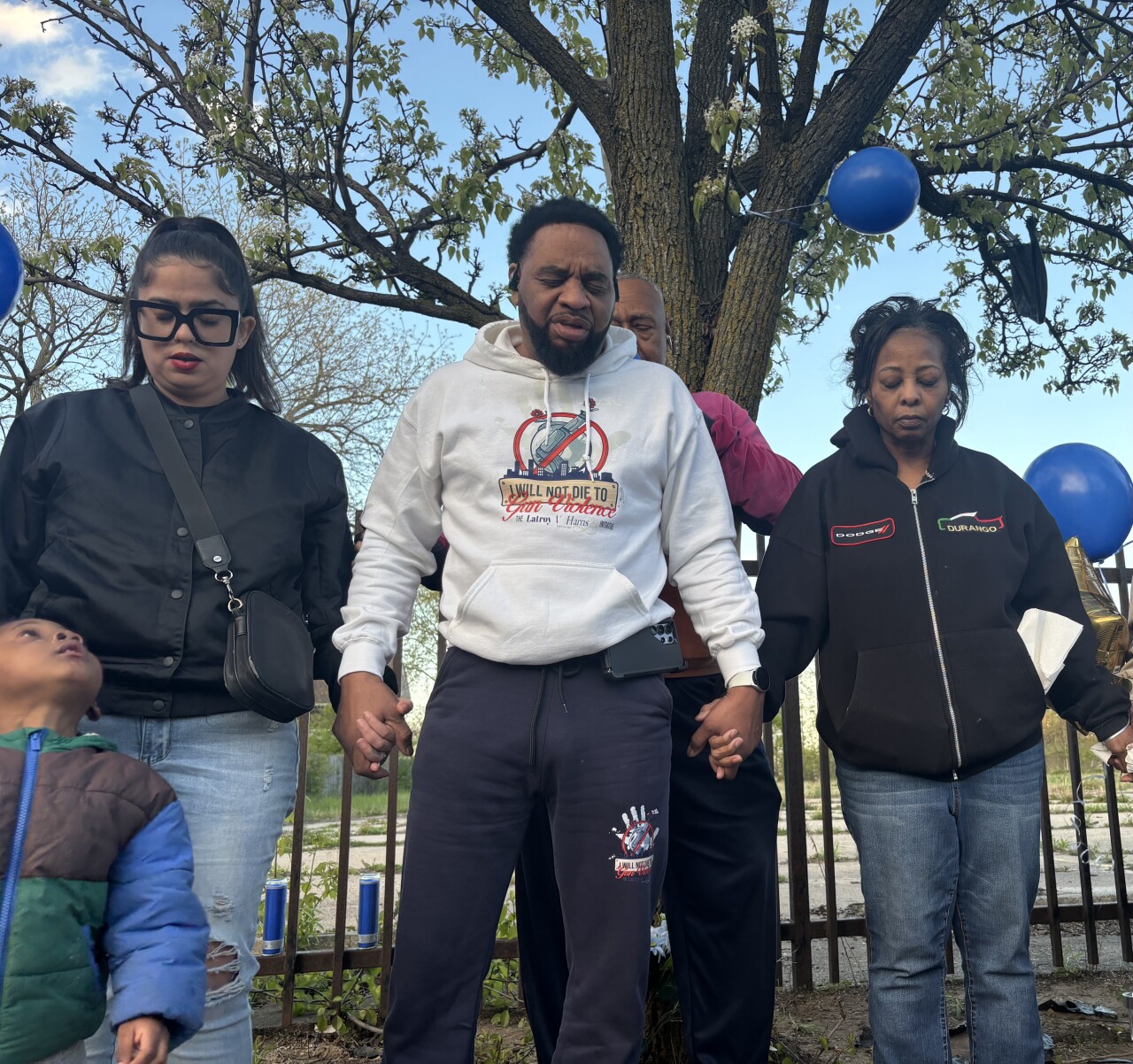 Daniela Cotto, Monte Mabra and Lisa Beatty all pray at a vigil for Dennis Johnson in Milwaukee
