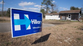 A Hillary Clinton sign sits in a yard.