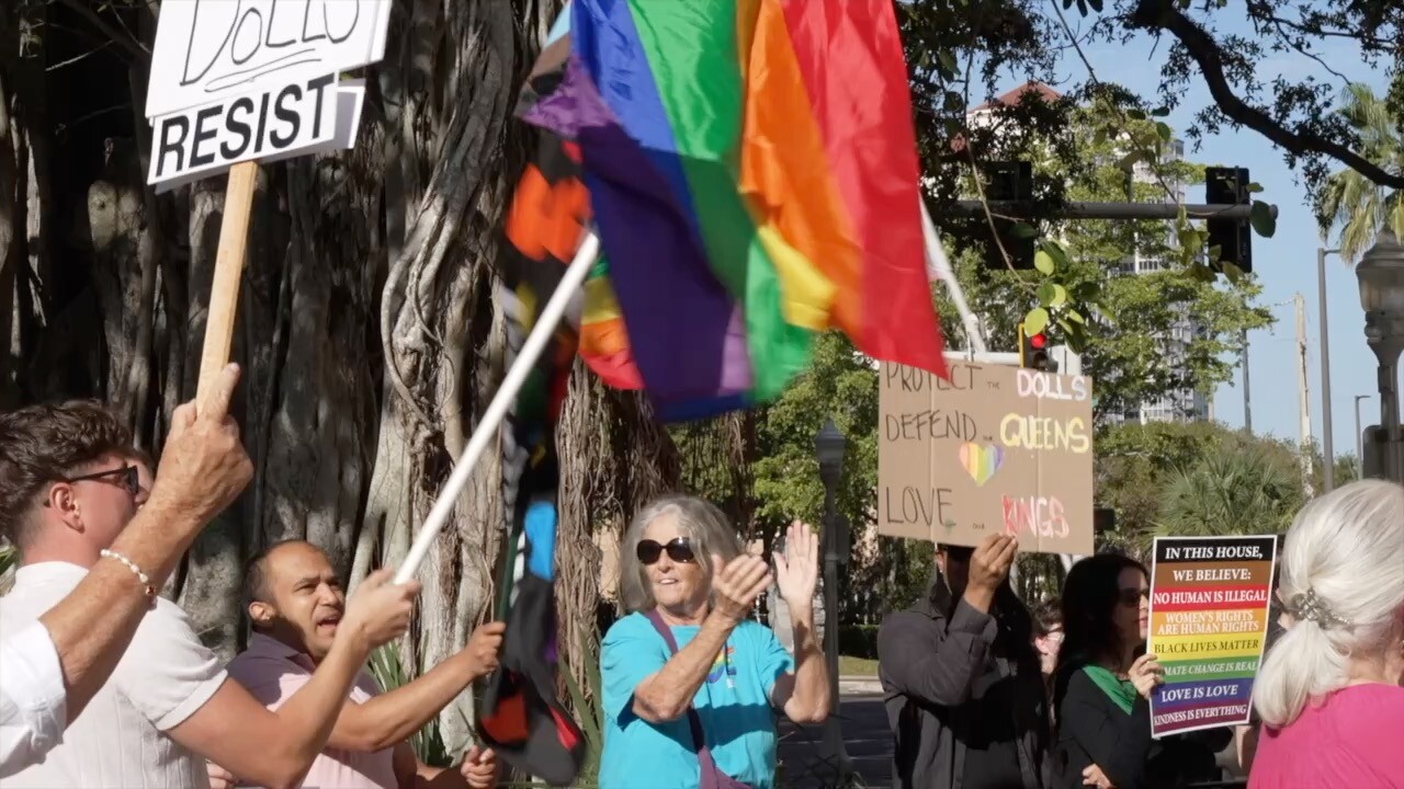 Naples protestors wave flags, those for and against Naples pride. 