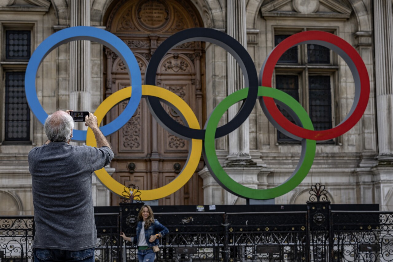 Man takes photos of Olympic rings in front of Paris City Hall, April 30, 2023