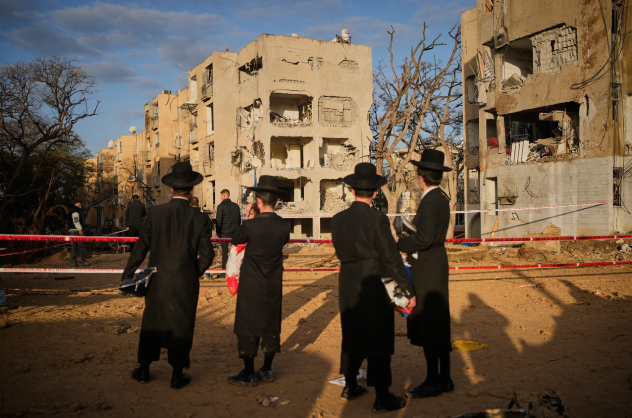 People look at residential buildings heavily damaged by an Iranian missile strike in Arad, southern Israel, Sunday, March 22, 2026.