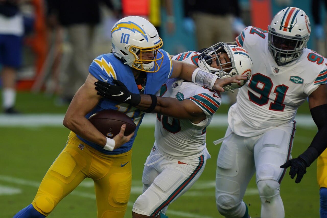 Los Angeles Chargers QB Justin Herbert fends off Miami Dolphins cornerback Nik Needham in 2020
