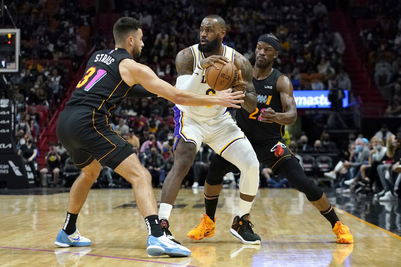 Los Angeles Lakers forward LeBron James looks to pass between Miami Heat guard Max Strus and forward Jimmy Butler, Jan. 23, 2022