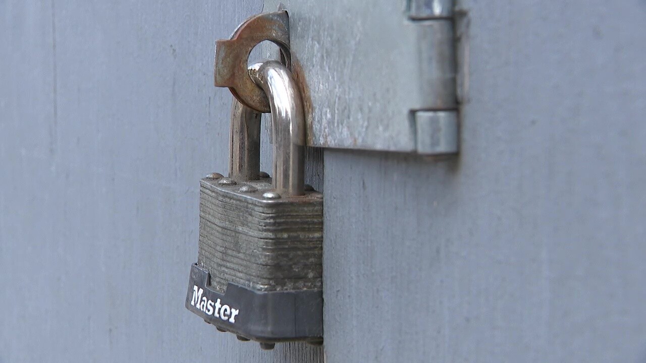 A padlock hangs on a boarded-up building on Buckeye Road.