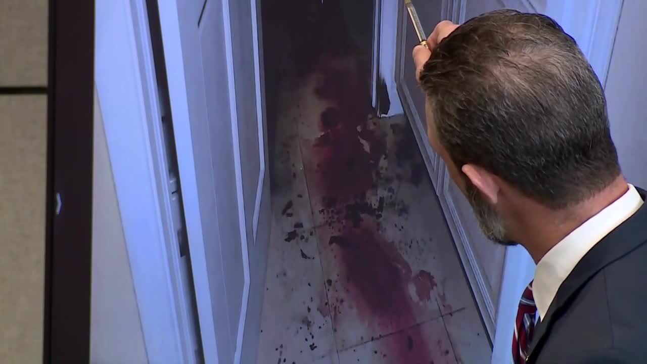 Assistant State Attorney Reid Scott points to picture of blood-stained floor as evidence on opening day of Jorge Dupre Lachazo murder trial, Jan. 23, 2023