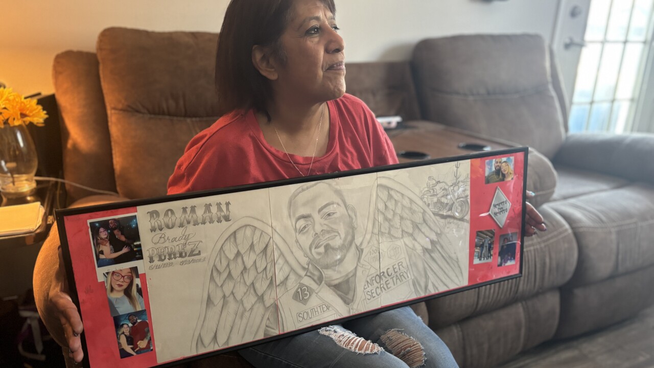 Letty Perez hold a drawing of her son Roman Perez with wings.