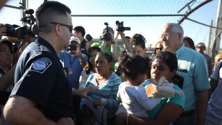 A U.S. Border Patrol agent tells asylum seekers that they will have to wait at the top of the Paso Del Norte Port of Entry.
