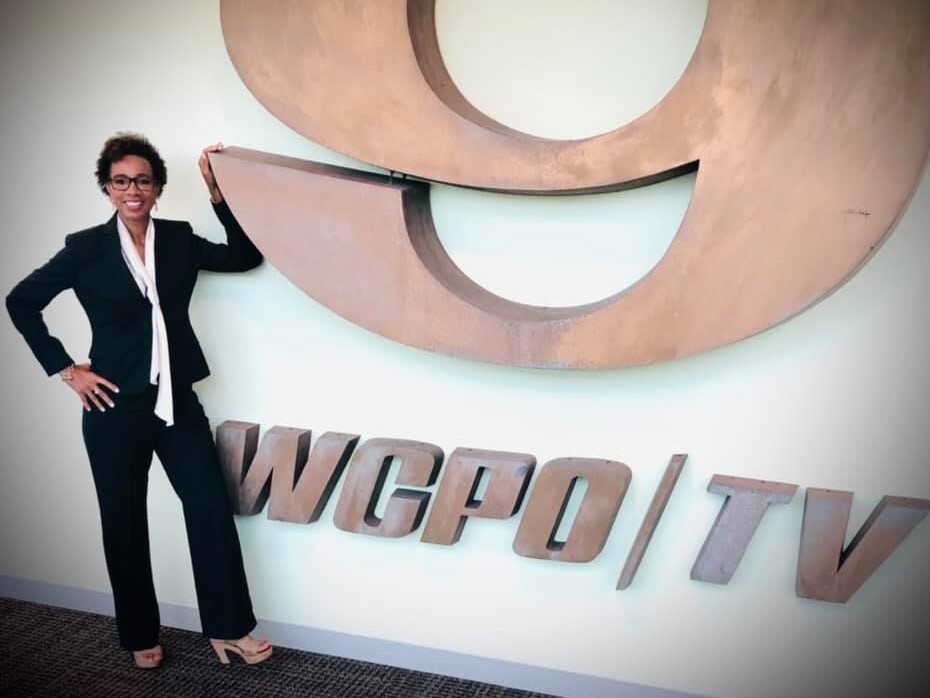 Sherry Hughes on Sept. 27, 2021, her 10-year anniversary at WCPO 9. She's wearing a dark suit and a white blouse, and she's standing by a large number nine.
