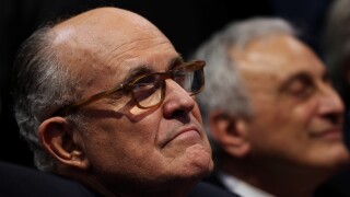 Former New York City Mayor Rudy Giuliani listens to a speech during an evening session of the Republican National Convention.