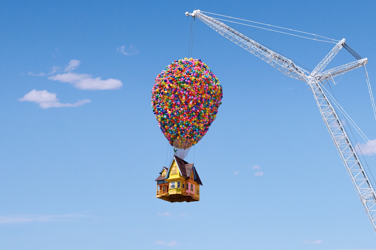 Airbnb's "Up" house, with 8,000 balloons, is held up by a crane.