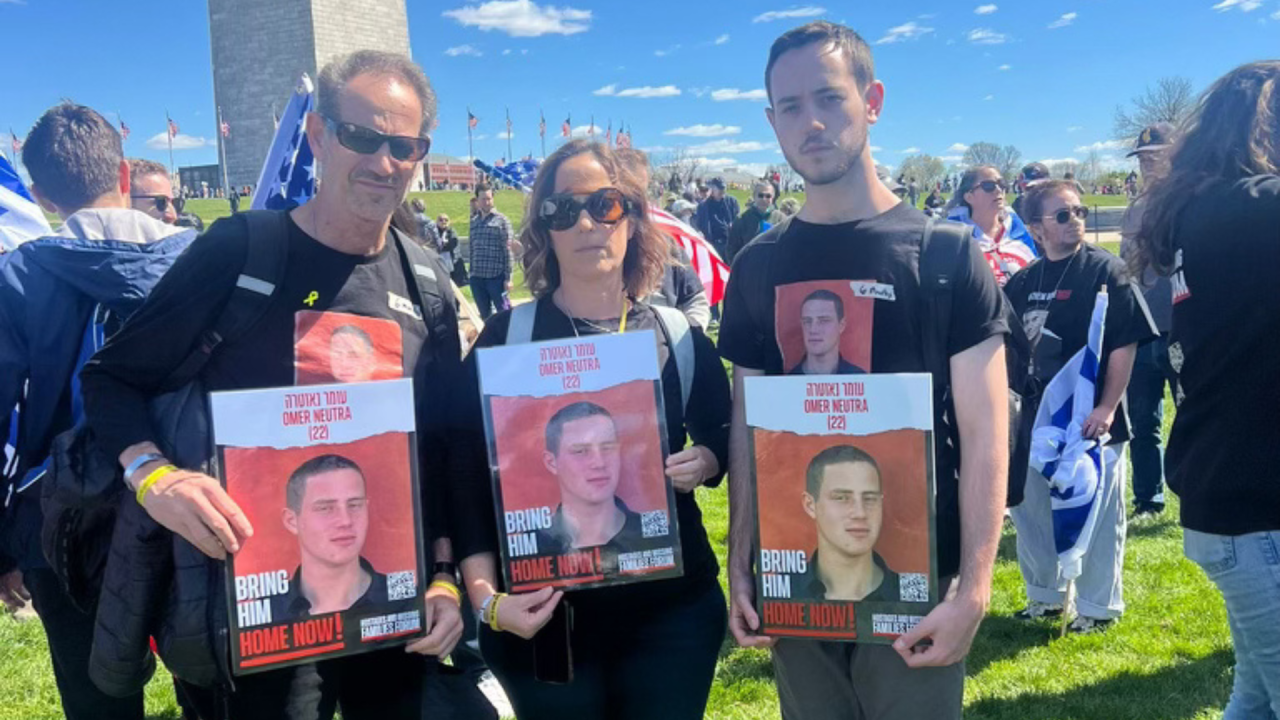 The Neutra family holding up signs demanding the release of Omer Neutra.