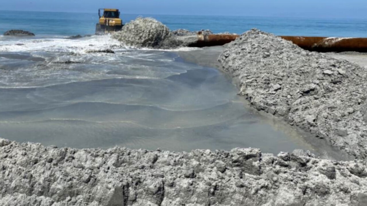 Example of pipe pumping sand onto a beach.