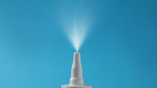 Nasal,Spray,With,Sprinkled,Medication,Over,Nozzle,On,Light,Blue