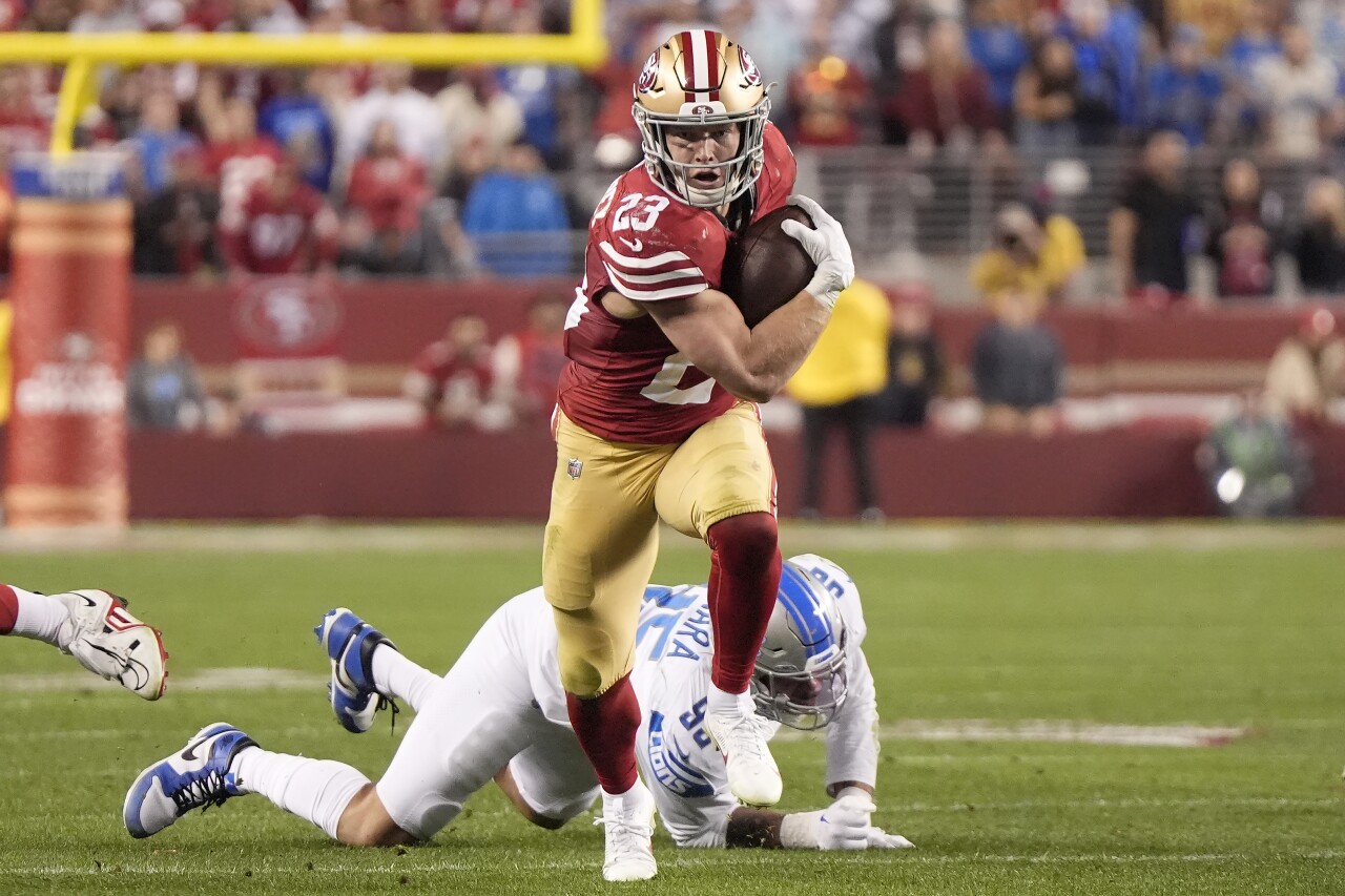 San Francisco 49ers running back Christian McCaffrey runs in front of Detroit Lions defensive end Romeo Okwara in second half of NFC Championship, Jan. 28, 2024