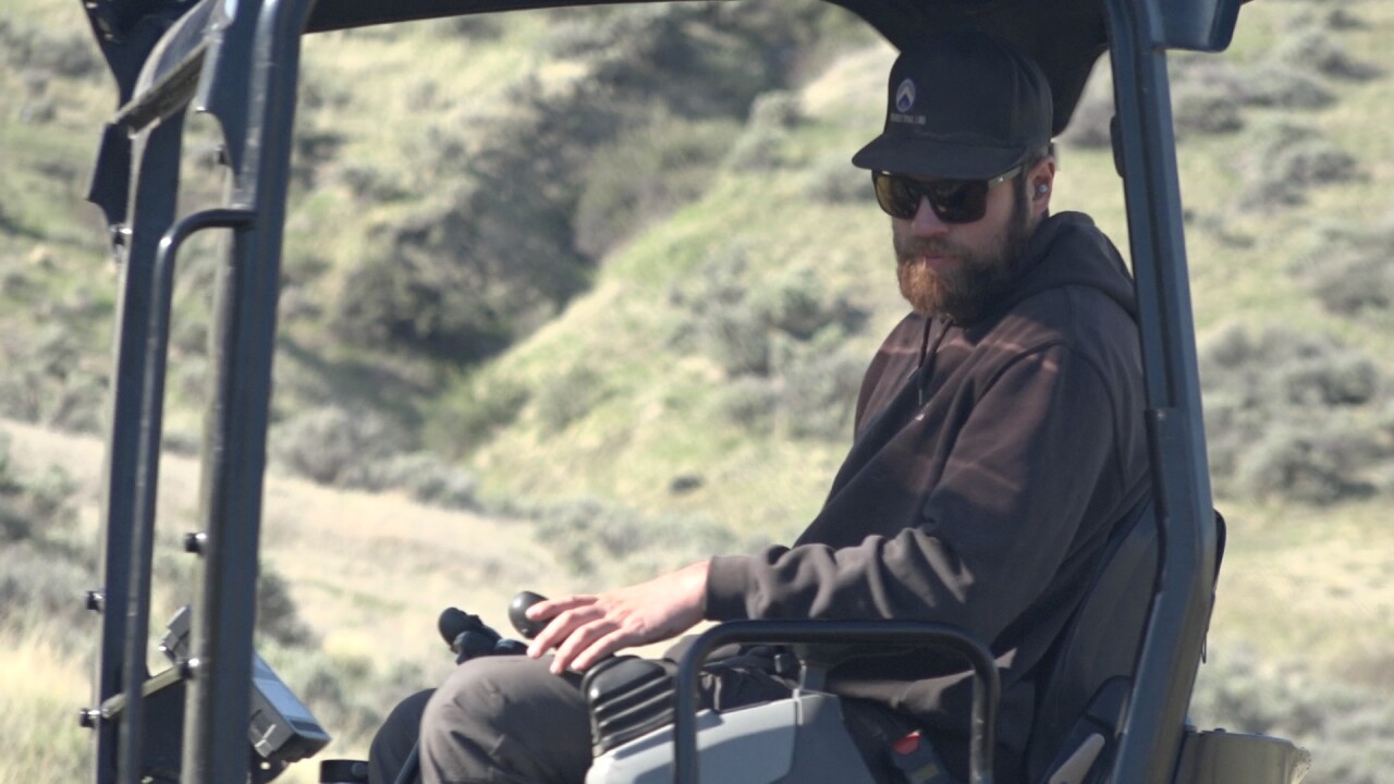 Spencer George operates machinery on the trail