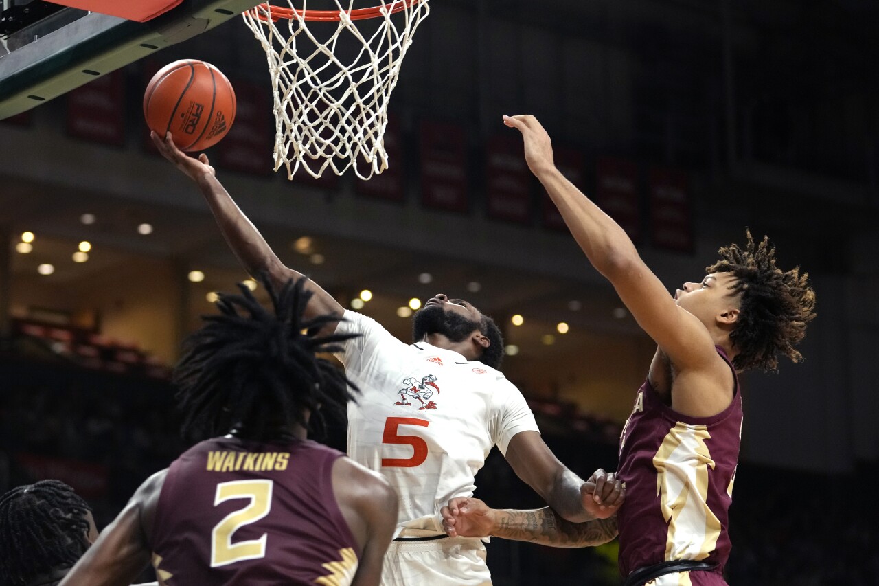 Miami Hurricanes guard Wooga Poplar goes to basket as Florida State Seminoles forward Cam Corhen defends during second half, Jan. 17, 2024