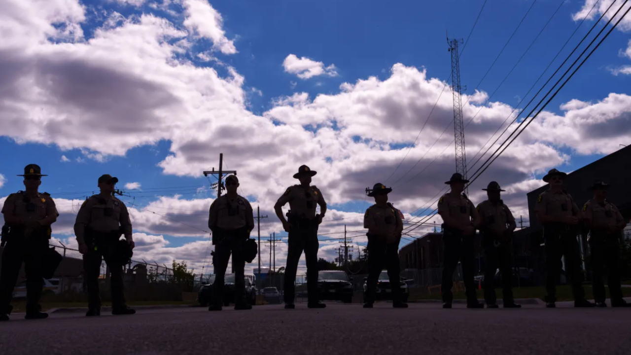 Illinois State Police stand guard as people including members of the Coalition for Spiritual and Public Leadership (CSPL) gather outside a U.S. Customs and Immigration Enforcement facility in Broadview, Ill., Saturday, Oct. 11, 2025.