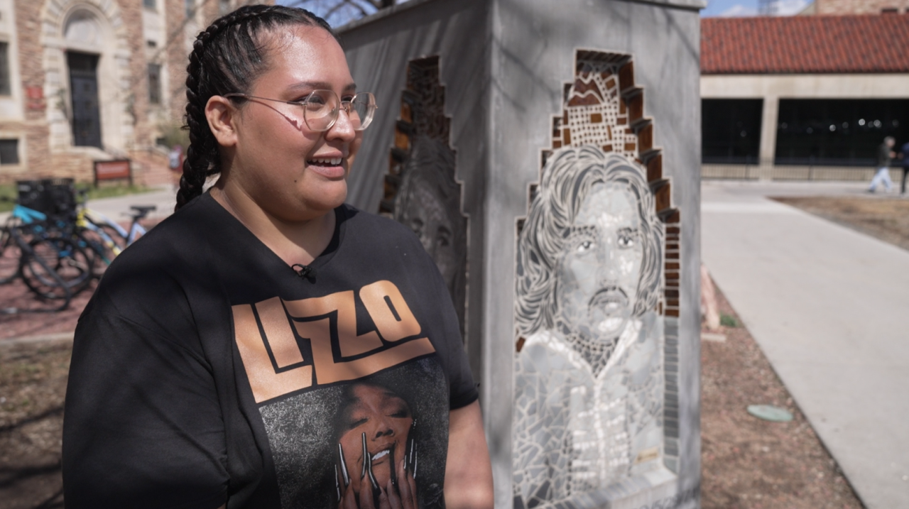 Gabby Mejia in front of Los Seis de Boulder sculpture